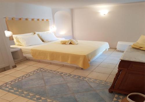 a bedroom with a bed and a tiled floor at Mykonian Dianthus in Elia Beach