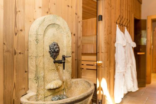 ein Bad mit einem Steinwaschbecken im Zimmer in der Unterkunft Hotel Burgfrieden in Gais
