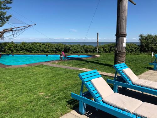 2 sillas azules sentadas junto a una piscina en Altrimo Hotel en Rybachiy