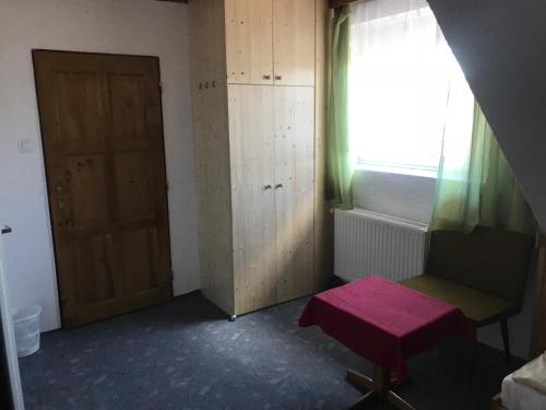 a room with a door and a bench and a window at Hotel Chata in Volary