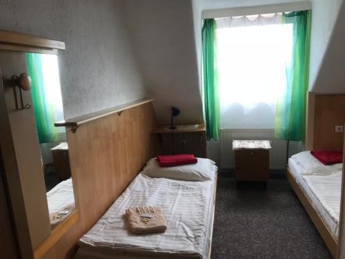 a room with two beds and a window with green curtains at Hotel Chata in Volary