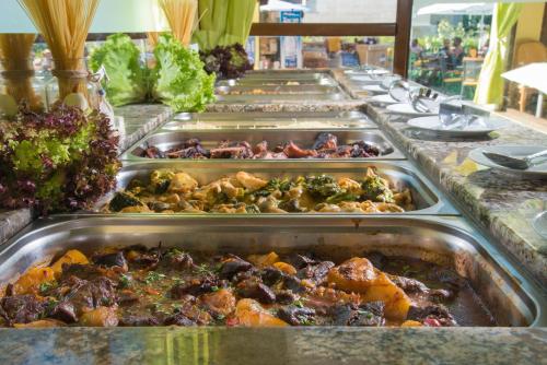 a row of trays of food on a buffet line at Aparthotel Hotel Prestige City II in Primorsko