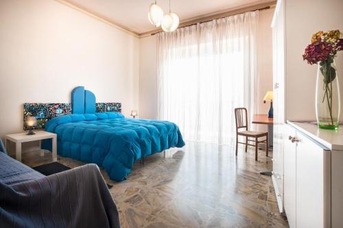 Un dormitorio con una cama azul y una mesa en Casa Giolele, en Acireale