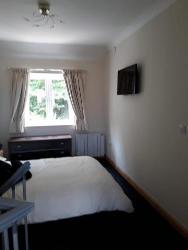 a bedroom with a white bed and a window at The Grove, Grove Road Ryde Po333lh in Ryde