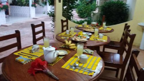 Chez Sabine في Abomey: طاولة خشبية عليها صحون طعام