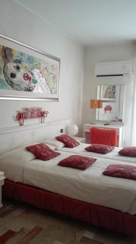 a bedroom with a large bed with red pillows at Art Hotel Al Fagiano in Padova