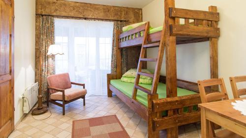 a bedroom with two bunk beds and a table at Lesna Chata in Jarosławiec