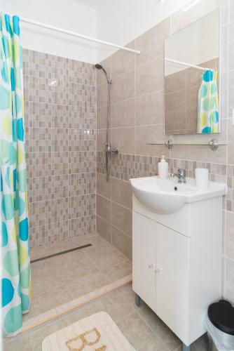 a bathroom with a sink and a shower at Nosztalgia Balaton Apartmanház in Vonyarcvashegy