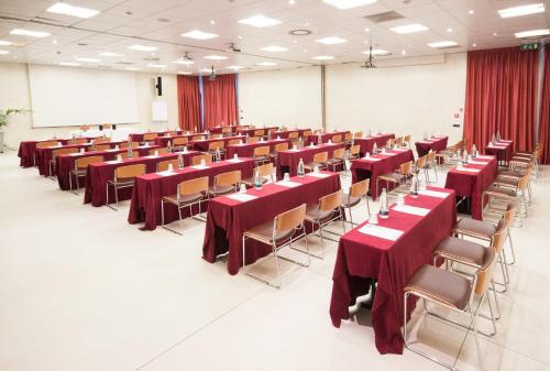 a large room with red tables and chairs at Best Western Modena District in Campogalliano