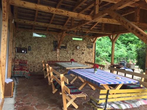 uma grande mesa de madeira e cadeiras num pavilhão em Guest House Mundzic- Sumski Mir em Irig