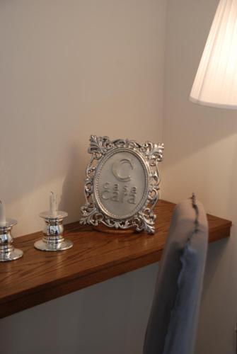 a clock sitting on a wooden shelf next to a lamp at Casa Cara in Birgu