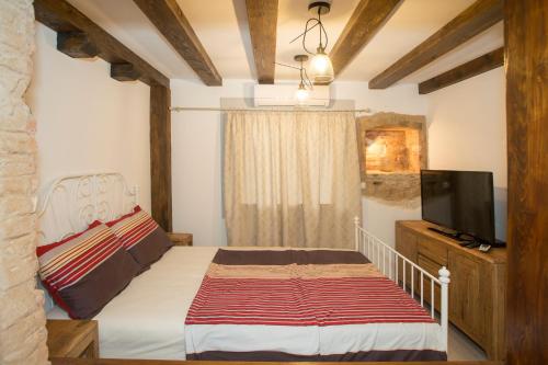 a bedroom with a bed and a flat screen tv at Dalmatian House in Split