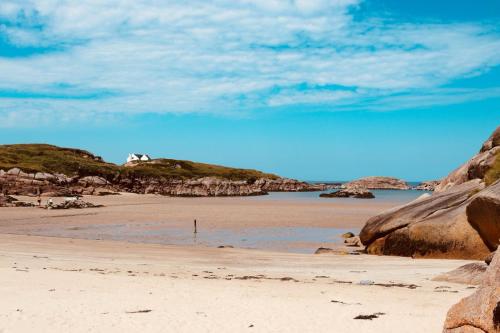 a sandy beach with a house on a hill at Hillcrest House Self Catering Apartments in Donegal