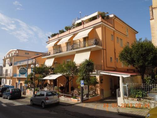 a tall building with cars parked in front of it at Delfino in Marina di Camerota