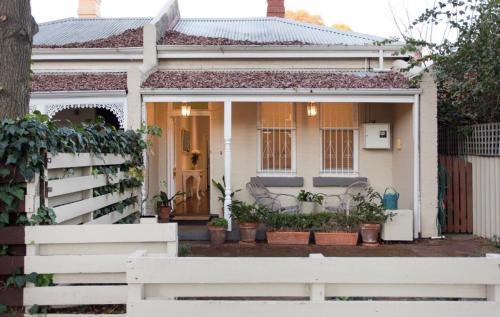a white fence in front of a white house at Gorgeous Subiaco cottage in Perth