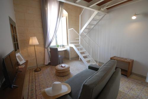 a living room with a couch and a staircase at Casa Cara in Birgu