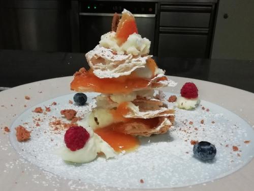 a piece of cake with fruit on a white plate at Hotel Park Oasi in Arta Terme