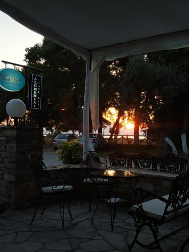 a patio with a table and chairs under an umbrella at BLEU- VERT in Prinos