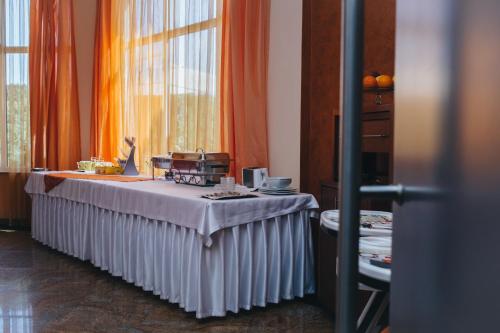 een tafel met een witte tafeldoek in een kamer bij Celly Hotel in Piteşti