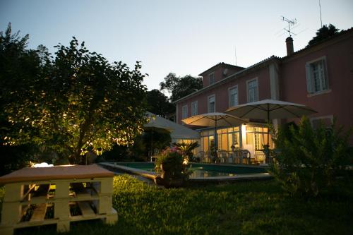 a yard with a house and a pool with umbrellas at Vila Duparchy in Luso