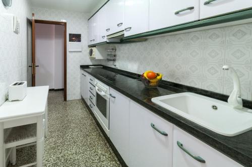 a kitchen with a sink and a bowl of fruit on the counter at Bunda in Playa de Gandia