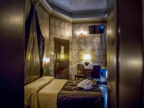 a hotel room with a bed and a table and a chair at Antica Dimora Delle Cinque Lune in Rome