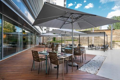 a patio with tables and chairs with umbrellas at Vincci Maritimo in Barcelona