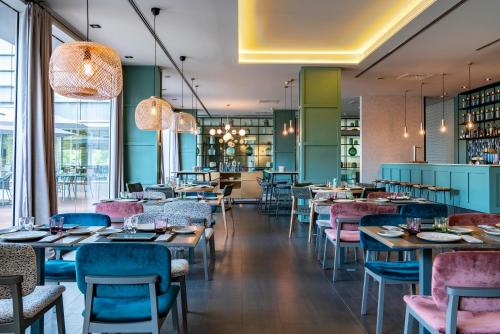 a restaurant with pink and blue chairs and tables at Vincci Maritimo in Barcelona