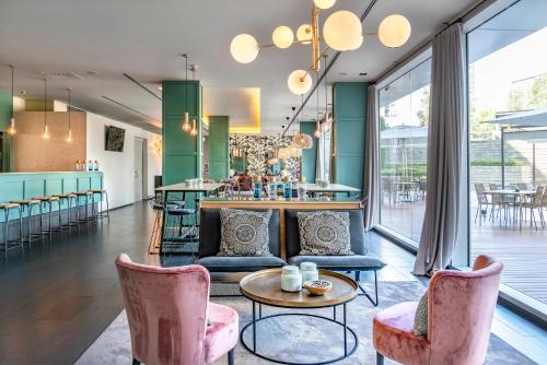 a living room with pink chairs and a bar at Vincci Maritimo in Barcelona