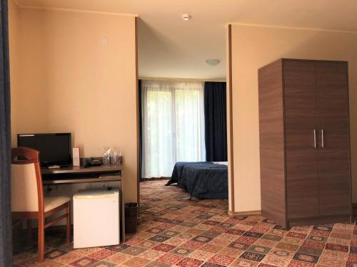 Schlafzimmer mit einem Bett und einem Schreibtisch mit einem Computer in der Unterkunft Hotel La Roka in Stara Sagora