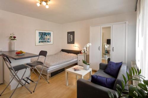1-Zimmer-Apartment Heßdorf في هيسدورف: غرفة معيشة صغيرة مع سرير وطاولة