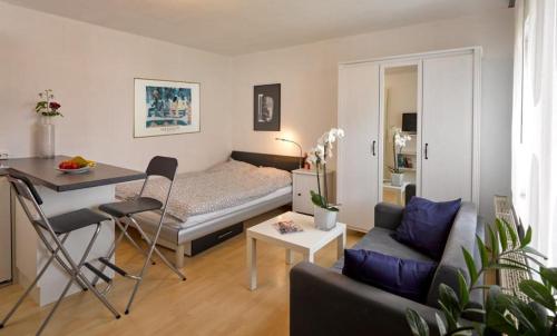 - un petit salon avec un lit et une table dans l'établissement 1-Zimmer-Apartment Heßdorf, à Heßdorf