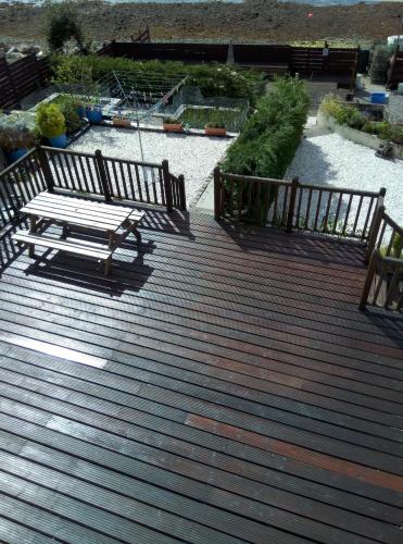 a wooden deck with a bench on top of it at Maggie's in Inveraray