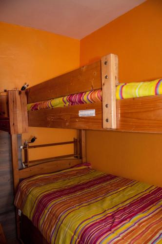 Ce lit superposé se trouve dans un dortoir doté d'un mur jaune. dans l'établissement Appartement proche station, à Luchon