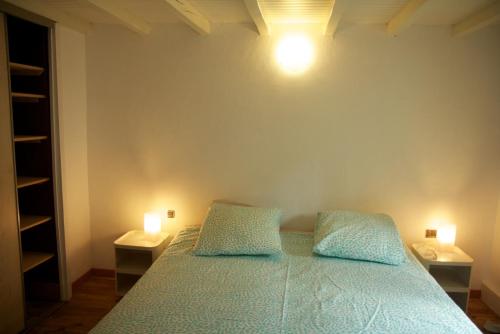 マルシアックにあるLa Maison WOAN centre de Marciacのベッドルーム1室(枕2つ、照明2つ付)