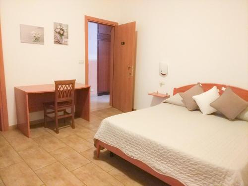 a bedroom with a bed and a desk and a table at Hotel Villa Souvenir in Forza dʼAgro