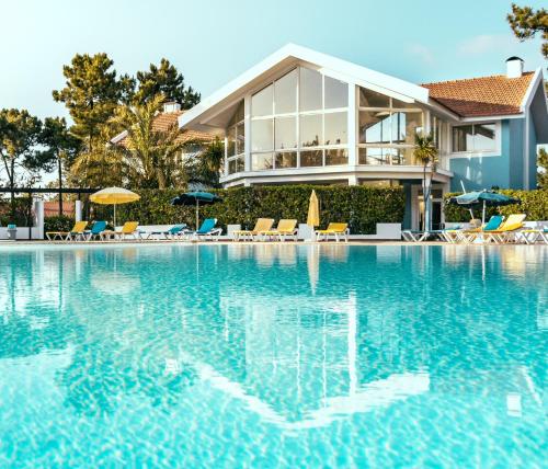uma piscina em frente a uma villa em Aldeamento Turistico Casas da Comporta na Comporta