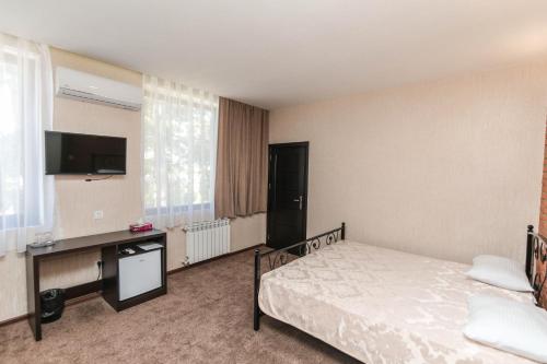 a hotel room with a bed and a desk at Evim Otel in Zaqatala