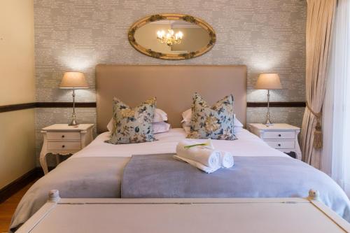 
a hotel room with two beds and two lamps at Berluda Farmhouse and Cottages in Oudtshoorn
