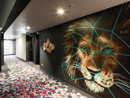 a large painting of a lion on a wall at Holiday Inn - the niu, Cobbles Essen by IHG in Essen