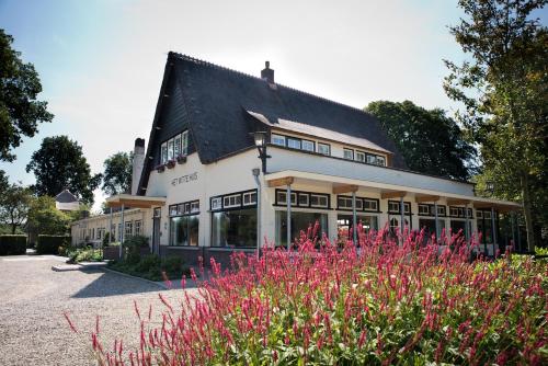 a building with a bunch of flowers in front of it at Hotel Restaurant Het Witte Huis in Olterterp