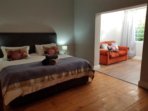 Settler Cottage Apartment في غراهامستاون: غرفة نوم مع سرير مع دمية دب عليها
