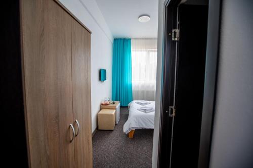 a room with a bedroom with a bed and a window at Pensiune Perla - Bistrița Năsăud in Susenii Bîrgăului