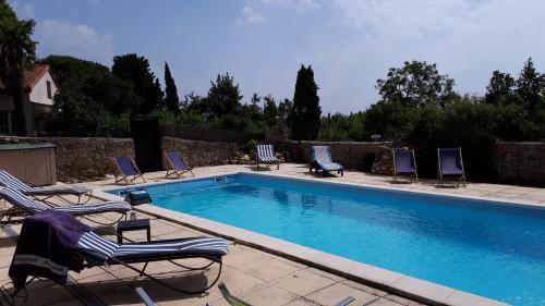 une piscine avec des chaises longues et une piscine dans l'établissement La Médéenne, à Alairac