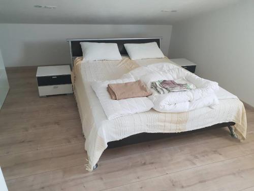 a bedroom with a large bed with white sheets and pillows at Apartments Nogic in Peroj