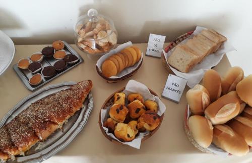 a table topped with different types of bread and pastries at Serra Plaza Hotel in Serrinha