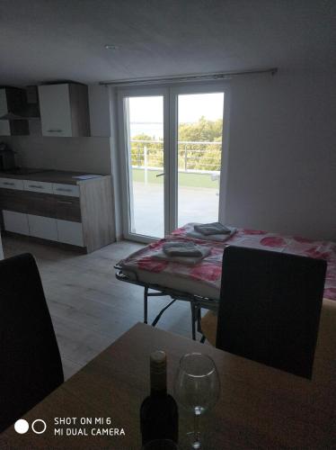 a room with a table and a kitchen with a window at Apartments Nogic in Peroj