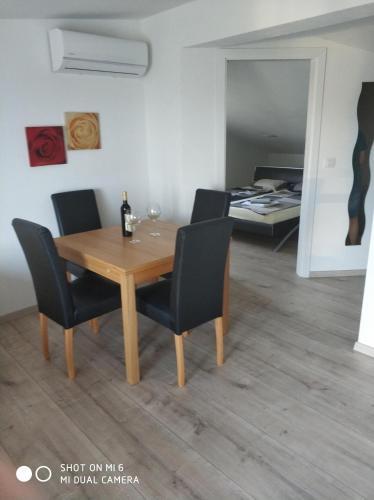 a dining room with a wooden table and chairs at Apartments Nogic in Peroj