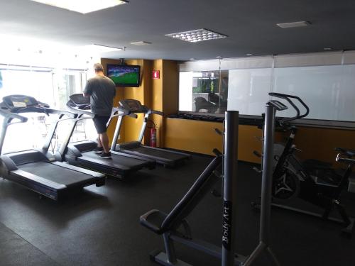 a man standing on a treadmill in a gym at Barreto Apart-hotel Kubit in Brasilia