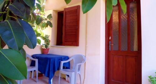een huis met een tafel en stoelen en een deur bij Katerina Palaiochora in Palaiochóra